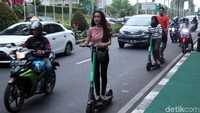 Seorang warga mengendarai skuter listrik di Jalan Sudirman, Jakarta, Kamis (14/11/2019).