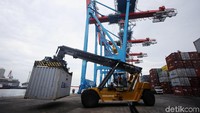 Sejumlah alat berat menurunkan peti kemas dari atas kapal di Pelabuhan Tanjung Priok.
