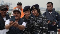 Seorang warga berfoto bersama dua prajurit TNI AL sebelum menaiki Kapal Angkatan Laut (KAL) Kobra di kawasan Pondok Dayung, Jakarta Utara.