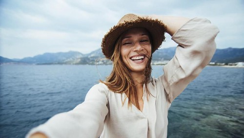 Frustrated young woman suffering from the headache while sitting on the sofa at home