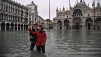 Tak sedikit juga wisatawan yang mengabadikan momen banjir itu lewat selfie atau swafofo (Marco Bertorello/AFP)