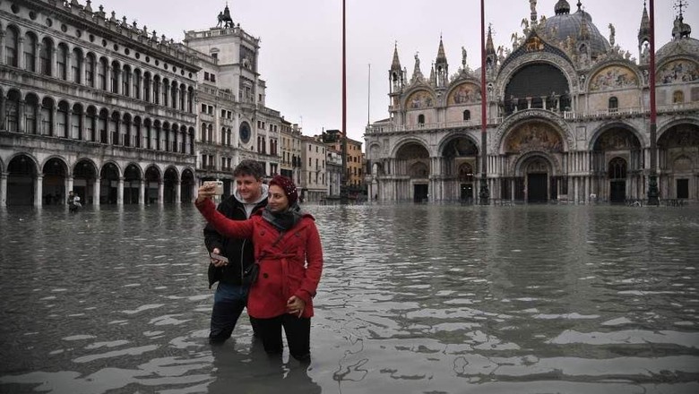 Wisatawan yang foto selfie di tengah banjir Venesia (AFP) Wisatawan yang foto selfie di tengah banjir Venesia (AFP)