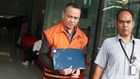 Eka Safitra keluar gedung KPK sambil menutupi tangannya yang diborgol.