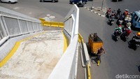 Selain berada di tengah jalan, tangga JPO Dewi Sartika ini berada di belokan jalan. Hal itu tentunya juga dapat membahayakan para pengguna jalan yang hendak melintasi JPO tersebut