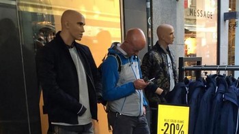 Bukan manekin. Yang di tengah adalah pria botak bermain smartphone (Bored Panda)