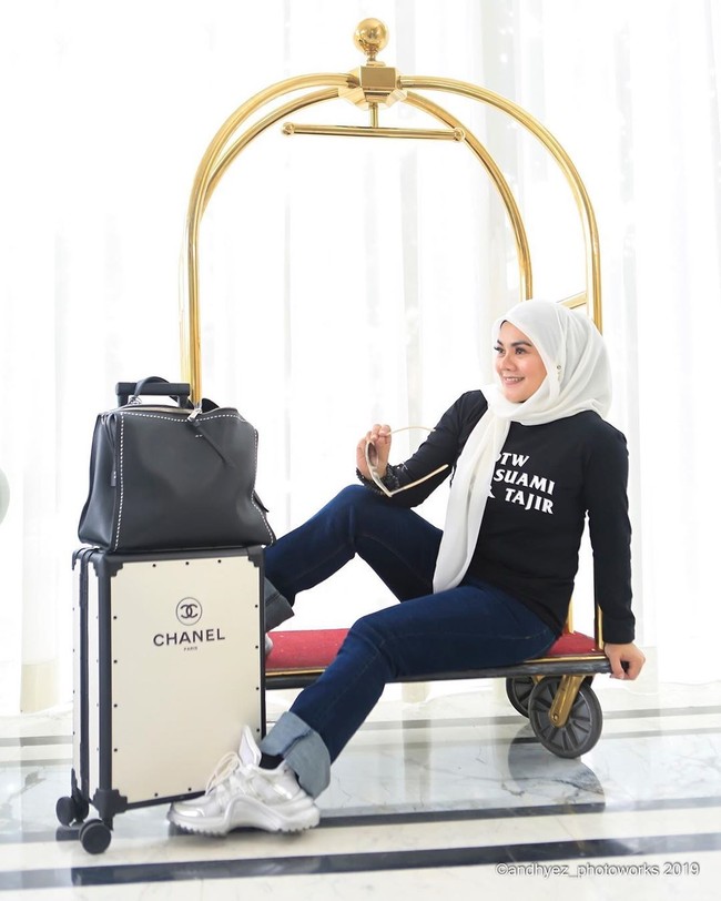 Dari foto-foto yang diunggahnya di Instagram terlihat Sarita menyukai busana serba monokrom. Dia sering terlihat memakai hijab dengan warna hitam atau putih. Seperti penampilannya di foto ini dia tampil dengan kaus dan celana denim serta jilbab putih. Tampak koper dari brand Chanel menemaninya bergaya. Foto: Dok. Instagram