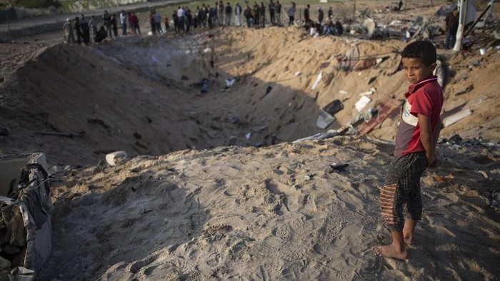 A Palestinian girl looks at the rubble of a destroyed house following overnight Israeli missile strikes, in the town of Khan Younis, southern Gaza Strip, Thursday, Nov. 14, 2019. (AP Photo/Khalil Hamra)