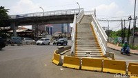 Untuk mengantisipasi terjadinya kecelakaan, pembatas jalan nampak dipasang di area sekitar tangga JPO tesebut.