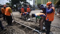 Petugas menggali pasir dan kerikil yang menutupi rel.