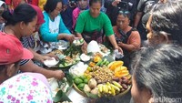 Syukuran dengan membagikan bancakan kepada pengunjung pasar.