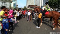 Tidak hanya anak-anak, para orang tua pun juga foto bersama polisi berkuda.