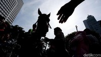 Warga mengantre untuk foto bersama polisi berkuda.