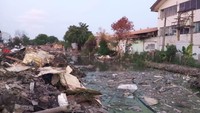 Sisa-sisa bangunan yang disebut sempat menghambar saluran air terlihat masih berada di pinggir saluran air tersebut. Petugas masih berupaya membersihkan bekas pengggusuran. (Farih Maulana/detikcom)