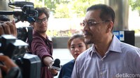 Ia terlihat memakai pakaian abu-abu.
