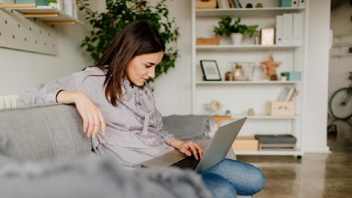 Woman sitting at a cafe working on digital tablet. Businesswoman sitting at cafe counter with a coffee using tablet computer.