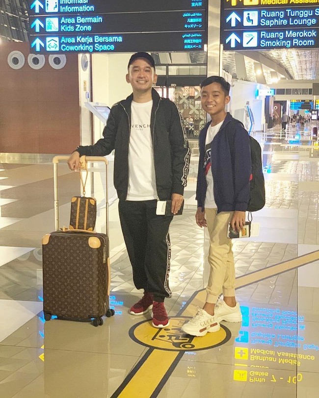 Betrand Peto yang berasal dari Manggarai, Nusa Tenggara Timur (NTT) diangkat oleh Ruben Onsu menjadi putranya. Setelah menjadi bagian dari keluarga Onsu, Betrand pun betransformasi menjadi anak laki-laki yang stylish. Seperti penampilan Betrand saat berada di bandara bersama sang ayah. Bocah 13 tahun itu tampil dengan sepatu Gucci yang harganya sekitar Rp 12 jutaan. Foto: dok. Instagram