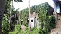 Dinding bangunan juga ditumbuhi rumput liar.