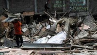 Warga mengevakuasi puing-puing yang masih bisa dimanfaatkan di sekitar lokasi gusuran.