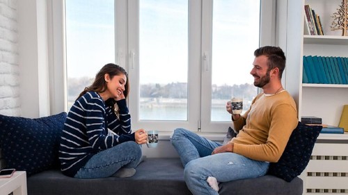 attractive asian couple talking in living room