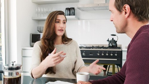 attractive asian couple talking in living room