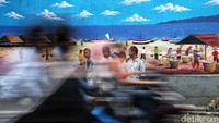 Sejumlah warga beraktivitas di kawasan kampung mural bertemakan alam di kawasan Kalibaru, Cilincing, Jakarta Utara, Selasa (19/11/2019).