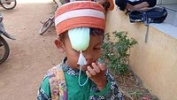 Daripada susah pegang makanan dan pegang minuman, mendingan minumannya diselipkan di kepala. Slurrrrp bisa makan sambil minum juga. Foto: istimewa