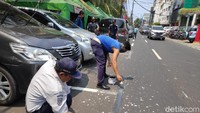 Marka parkir berwarna putih awalnya dikerik atau diketok dengan palu. Setelahnya, petugas mengecat marka parkir dengan warna hitam sesuai dengan warna aspal (Matius Alfons/detikcom)
