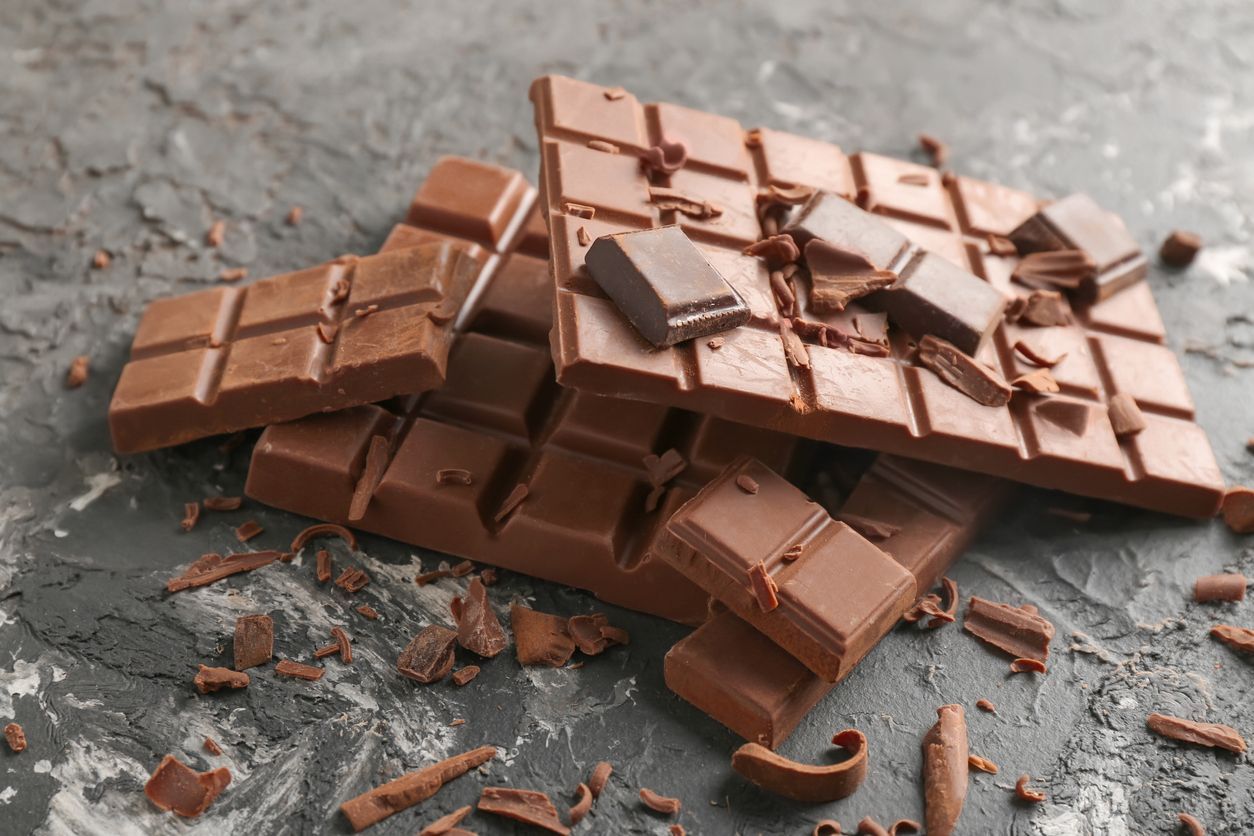 Closeup portrait of a cute young female biting into a piece of chocolate