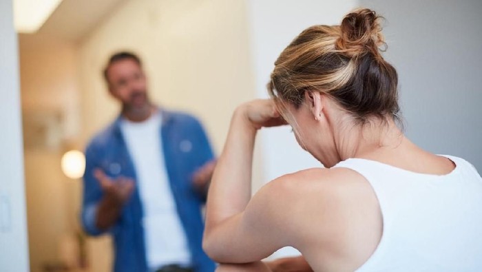 Rearview shot of an unrecognizable young woman looking distressed with her husband in the background