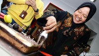 Risma mulai memotong kue.