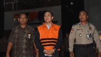 Toto keluar dari gedung KPK sekitar pukul 20.00 WIB. Ia keluar memakai rompi tahanan dengan tangan diborgol.