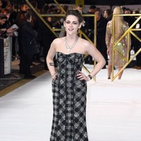 Kristen sendiri muncul dalam balutan gaun strapless gelap bermotif kotak-kotak rancangan Thom Brown. Gaun dari koleksi Resort 2019 itu hadir dengan pinggul dekonstruktif sebagai aksen. (Foto: Gareth Cattermole/Getty Images)