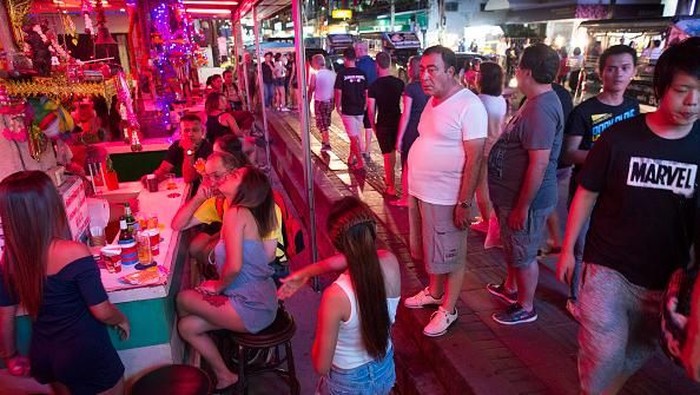 PATTAYA,THAILAND -JULY 31, 2016:  Bar girls entertain men at a bar along the Walking Street where bars and sex scenes are a commonplace July 31, 2016 in Pattaya, Thailand. Thailands first female minister of tourism would like the sex trade that is a huge business in the country to be banned. Tourists flock to Thailand for many sights including beautiful beaches but also for sex tourism. Cities like Bangkok and Pattaya are well known as hubs of the Southeast Asian sex trade, despite the fact that prostitution has been illegal in Thailand since 1960.(Photo by Paula Bronstein/ Getty Images)
