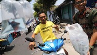 Anggota kelompok budidaya ikan membagikan ikan cupang kepada pengguna jalan di Ngasem, Kediri, Jawa Timur, Rabu (20/11/2019). Kegiatan makan olahan ikan bersama-sama sekaligus membagikan dua ribu ekor ikan cupang dan empat ribu ekor ikan komet tersebut diselenggarakan pemerintah daerah setempat guna memperingati Hari Ikan Nasional. ANTARA FOTO/Prasetia Fauzani.