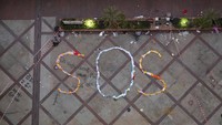 Para demonstran pun diimbau untuk menyerahkan diri. Meski ada sejumlah demonstran yang akhirnya menyerahkan diri karena kondisi kesehatan yang memburuk dan kondisi stok makanan yang kian menipis, masih ada sejumlah demonstran yang memilih untuk bertahan di dalam kampus. Mereka pun membentuk kalimat SOS dengan menggunakan pakaian dan helm untuk memberikan tanda terkait kondisi mereka tersebut. Kin Cheung/AP Photo.