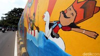 Mural berbagai warna tersebut membuat dinding di sisi Pintu Air Manggarai nampak cerah dan berwarna.