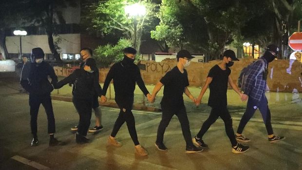 Sejumlah demonstran keluar dari kampus Hong Kong untuk menyerahkan diri ke polisi