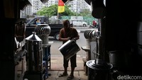 Seorang perajin nampak menyusun dandang dan berbagai peralatan memasak lainnya di kawasan Cawang, Jakarta, Jumat (22/11/2019).