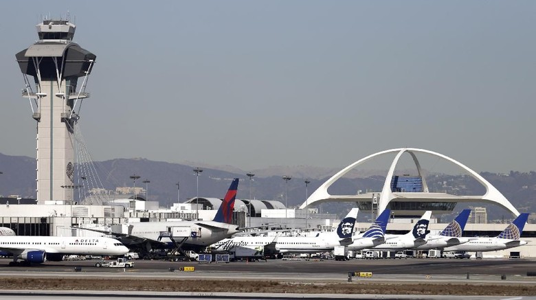 FILE - In this Nov. 1, 2013 file photo airplanes sit on the tarmac at Los Angeles International Airport. A Philippine Airlines jet with flames spurting from one engine has returned safely to Los Angeles International Airport shortly after takeoff. Ian Gregor of the Federal Aviation Administration says Flight 113, a Boeing 777 bound for Manila, reported a problem with the right engine after takeoff Thursday, Nov. 21, 2019. It turned around and landed safely at about noon. (AP Photo/Gregory Bull,File)