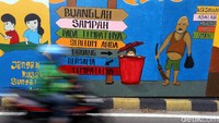 Seorang pengendara motor melintas di samping dinding yang dihias mural di Pintu Air Manggarai, Jakarta, Jumat (22/11/2019).
