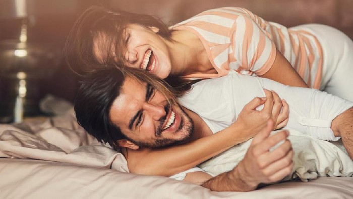 686509338 Happy young playful couple in bed.