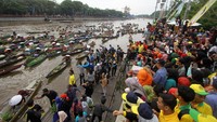 Ribuan masyarakat memenuhi tepi sungai untuk berlomba mendapatkan buah dan syuran yang dibagikan gratis.