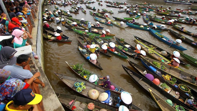 REKOR MURI PEMBAGIAN SAYUR DAN BUAH DARI JUKUNG Sejumlah pedagang pasar terapung membagikan sayur dan buah di sungai Martapura, Banjarmasin, Kalimantan Selatan, Minggu (24/11/2019). Sebanyak 374 pedagang pasar terapung berhasil memecahkan Rekor Museum Indonesia (MURI) sebagai rekor pembagian sayuran dan buah dari jukung terbanyak. ANTARA FOTO/Bayu Pratama S/aww.