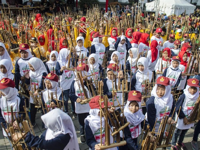 Sejumlah pelajar SD memainkan alat musik angklung secara bersama pada acara Angklungs Day 2019 di Gedung Sate, Bandung, Jawa Barat, Minggu (24/11/2019). Angklungs Day 2019 yang bertemakan Feel The Worlds Sensation tersebut guna memperingati alat musik angklung sebagai warisan budaya dunia tak benda oleh UNESCO serta untuk menggali nilai tradisional dalam berkesenian dan berkebudayaan bagi generasi muda. ANTARA FOTO/Novrian Arbi/aww.