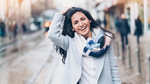 Smiling young woman walking in the city