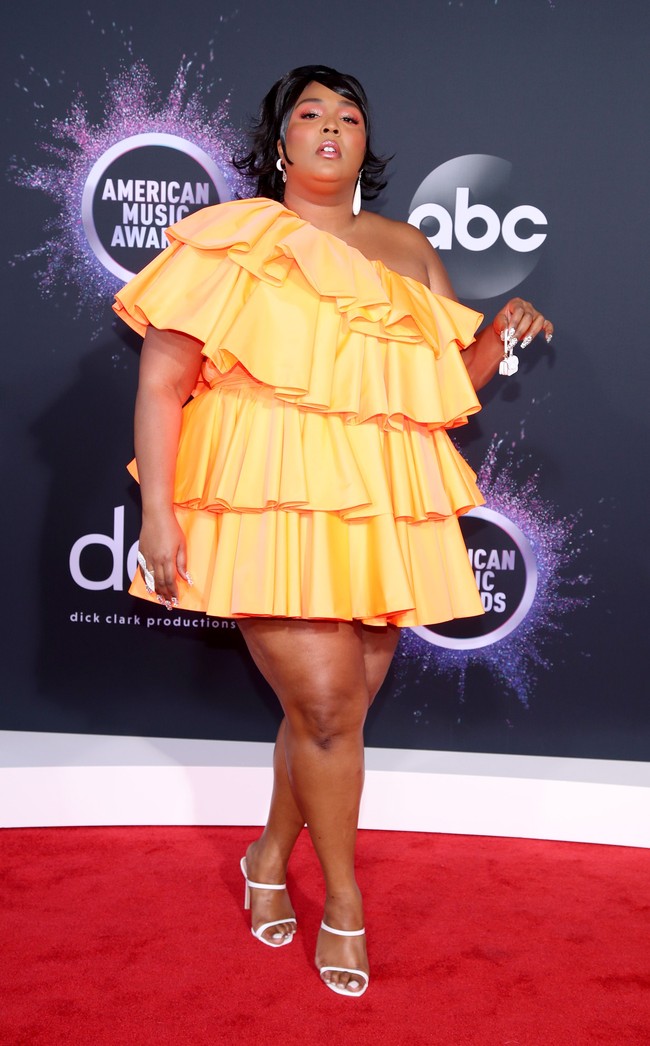 Tidak ketinggalan, sepasang sandal heels putih minimalis dari Stuart Weitzman juga menemani penampilan penyanyi yang juga jago meniup flute. (Foto: Getty Images)