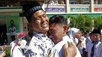 Pelajar memberikan ucapan selamat dengan memeluk gurunya seusai upacara peringatan hari guru nasional dan HUT Persatuan Guru Republik Indonesia (PGRI) di MTsN Model, Banda Aceh, Aceh, Senin (25/11/2019). ANTARA FOTO/Irwansyah Putra.