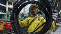 Petugas merapikan kabel yang sudah dipotong.