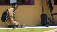 Seorang guru CPNS, Mohamat Hikmat (26), menaiki papan luncur di Sekolah Luar Biasa (SLB) Kabupaten Batang, Jawa Tengah, Senin (25/11/2019).