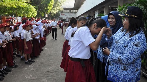Sejumlah siswa menyalami guru mereka seusai mengikuti upacara di Sekolah Dasar Negeri 060813 Medan, Sumatera Utara, Senin (25/11/2019). Menyalami guru oleh para siswa tersebut dalam rangka memperingati Hari Guru yang serentak dilaksanakan di seluruh Indonesia. ANTARA FOTO/Septianda Perdana/foc.